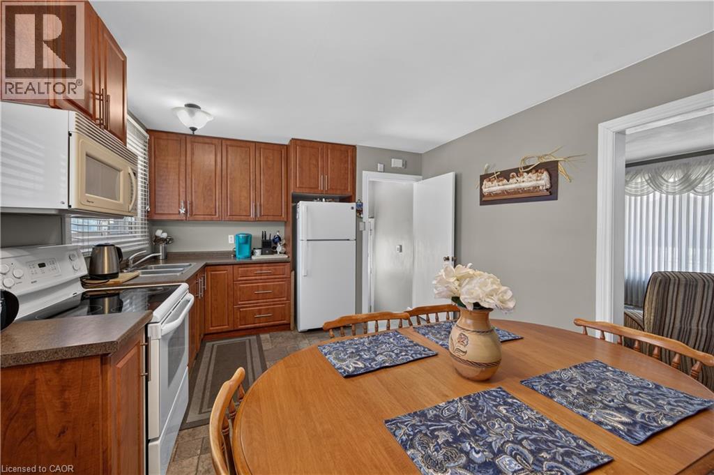 Kitchen featuring wood-finish cabinetry, white appliances, and a double basin sink - 5 Kentley Drive, Hamilton, ON - Indoor Photo Showing Kitchen
