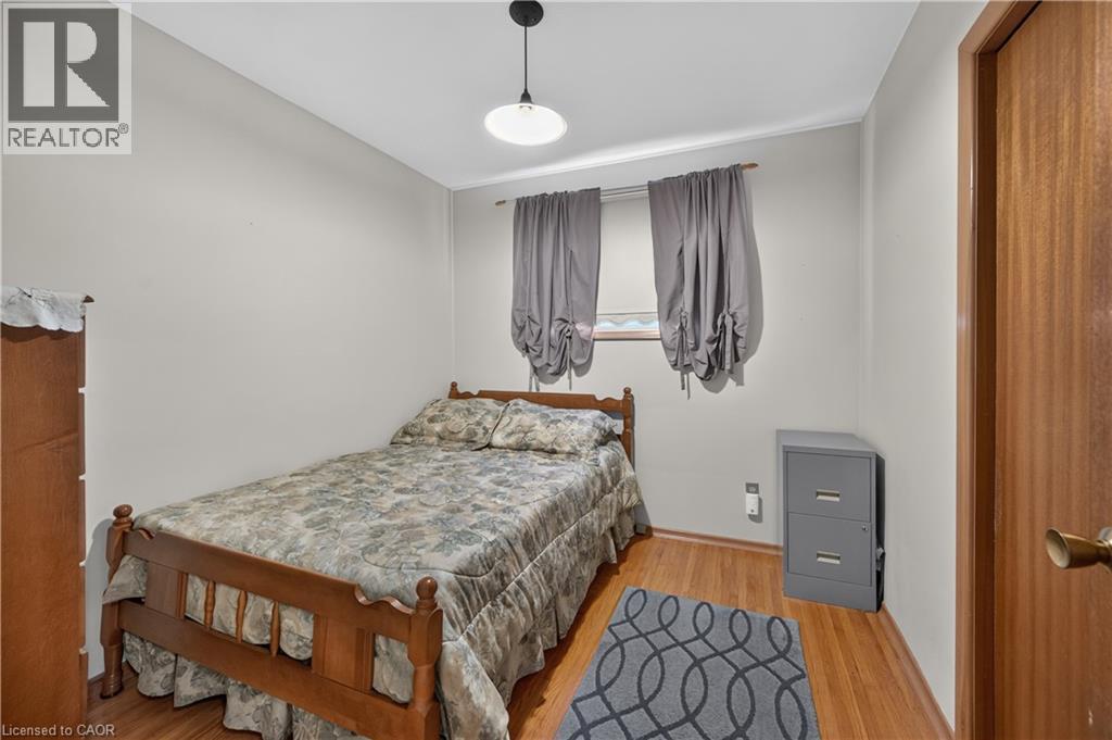 Hardwood-finish flooring, white painted walls, and a ceiling-mounted light fixture - 5 Kentley Drive, Hamilton, ON - Indoor Photo Showing Bedroom
