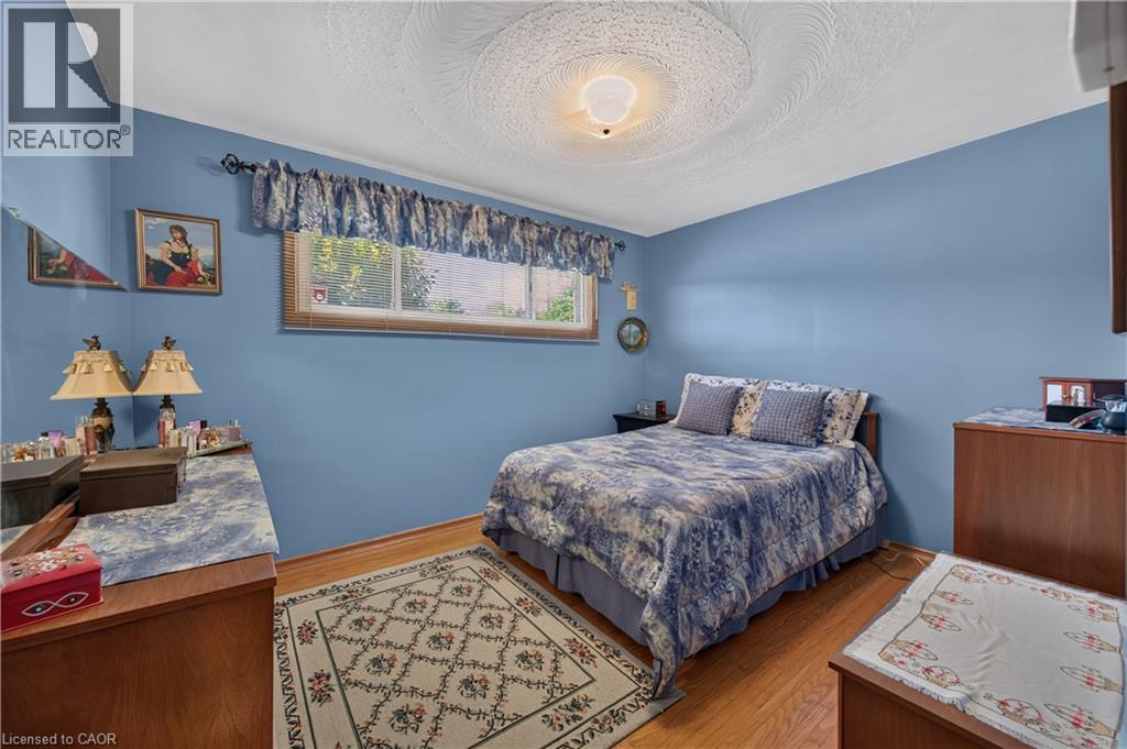 Hardwood-finish flooring, textured ceiling, window with natural light, and neutral wall color - 5 Kentley Drive, Hamilton, ON - Indoor Photo Showing Bedroom