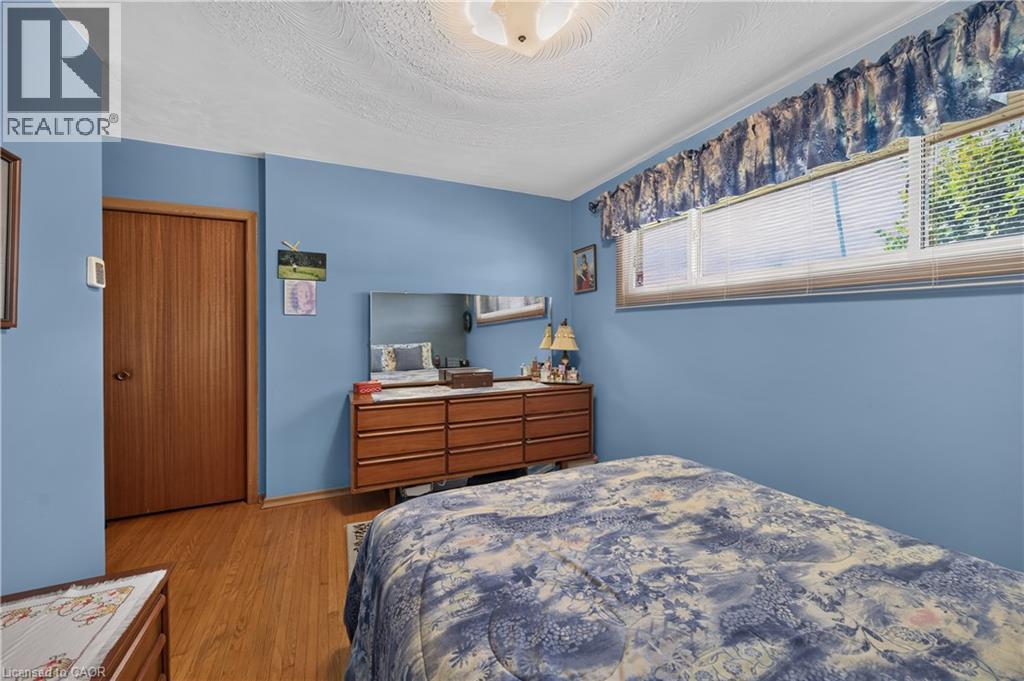 Wood-finish flooring, light blue wall paint, and a window with blinds - 5 Kentley Drive, Hamilton, ON - Indoor Photo Showing Bedroom