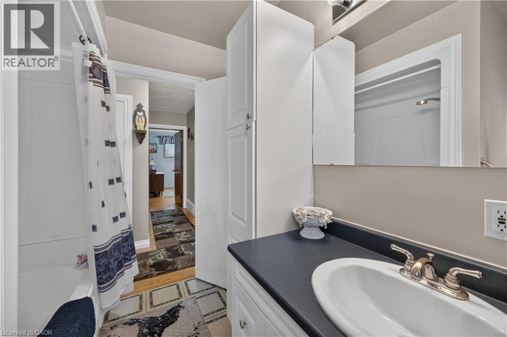 Bathroom featuring a vanity with an integrated sink, dual-handle faucet, and white cabinetry - 5 Kentley Drive, Hamilton, ON - Indoor Photo Showing Bathroom