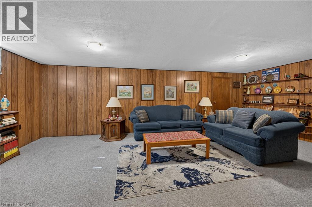 Wall paneling, built-in shelving, ceiling-mounted light fixtures, and carpeted flooring - 5 Kentley Drive, Hamilton, ON - Indoor Photo Showing Living Room