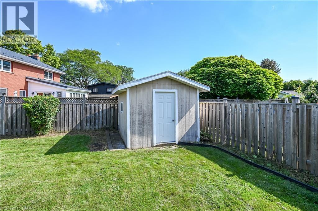 Expansive lawn area featuring a storage shed and wood privacy fencing - 5 Kentley Drive, Hamilton, ON - Outdoor