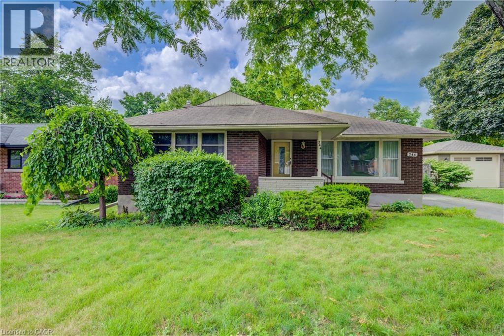 Brick exterior with a covered porch, established shrubbery, and a mature weeping tree in the front yard - 244 Royal Street, Waterloo, ON - Outdoor