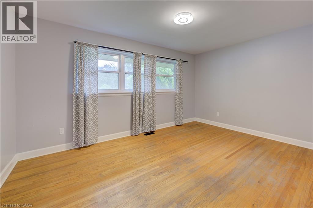 Wood-finish flooring, light gray wall paint, and multiple windows - 244 Royal Street, Waterloo, ON - Indoor Photo Showing Other Room