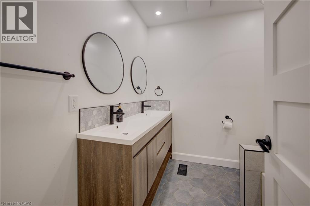 Dual vanity with wood-finish cabinetry, white countertop, and black fixtures - 244 Royal Street, Waterloo, ON - Indoor Photo Showing Bathroom