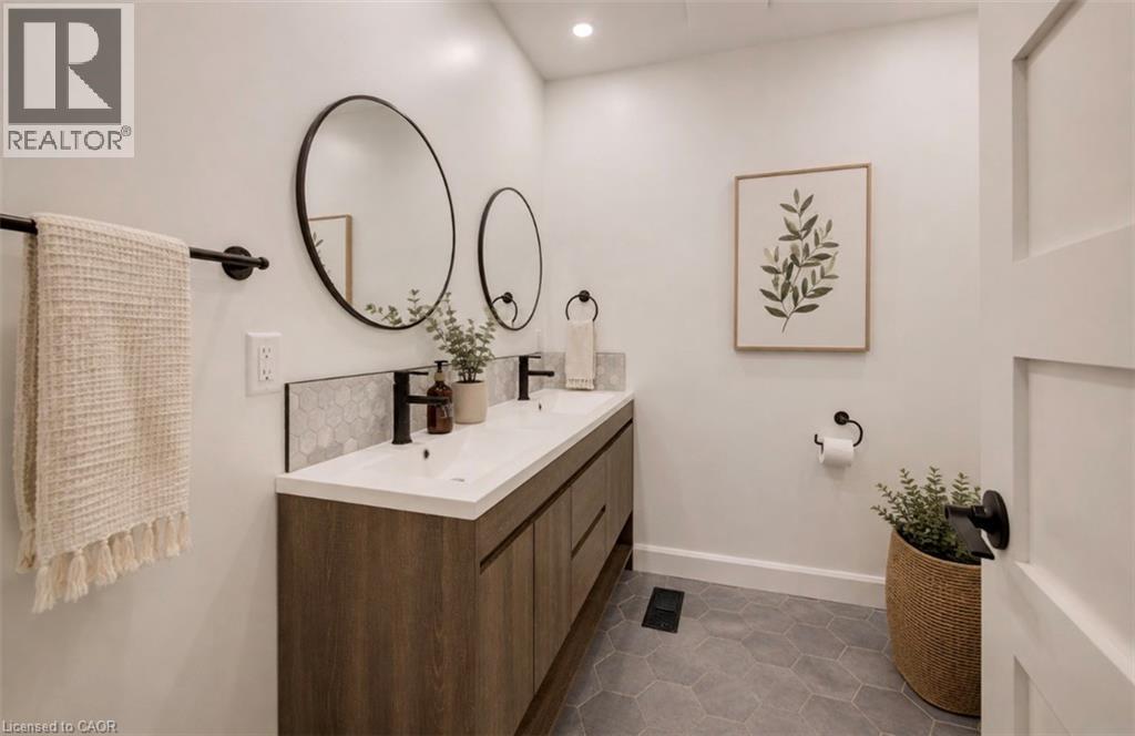 Dual vanity with wood-finish cabinetry, white countertop, and matte black fixtures - 244 Royal Street, Waterloo, ON - Indoor Photo Showing Bathroom