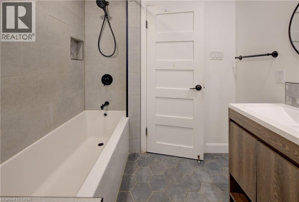 Contemporary bathroom featuring a tub with matte black fixtures, an in-shower niche, and hexagonal floor tiling - 244 Royal Street, Waterloo, ON - Indoor Photo Showing Bathroom