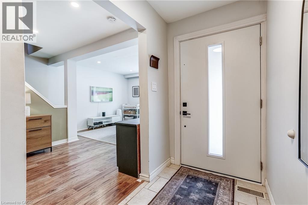 Entryway featuring a solid white door with a vertical frosted glass insert, ceramic tile flooring, and recessed lighting - 2488 Brookhurst Road, Mississauga, ON - Indoor