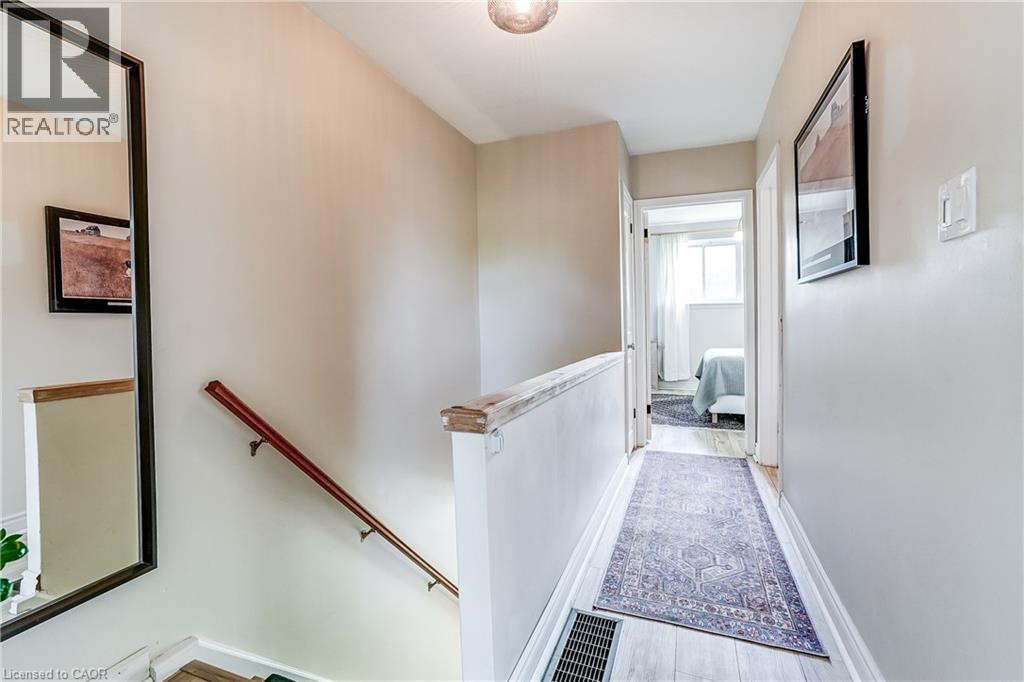 Light-toned wood-finish flooring, white painted walls, and a wood handrail - 2488 Brookhurst Road, Mississauga, ON - Indoor Photo Showing Other Room