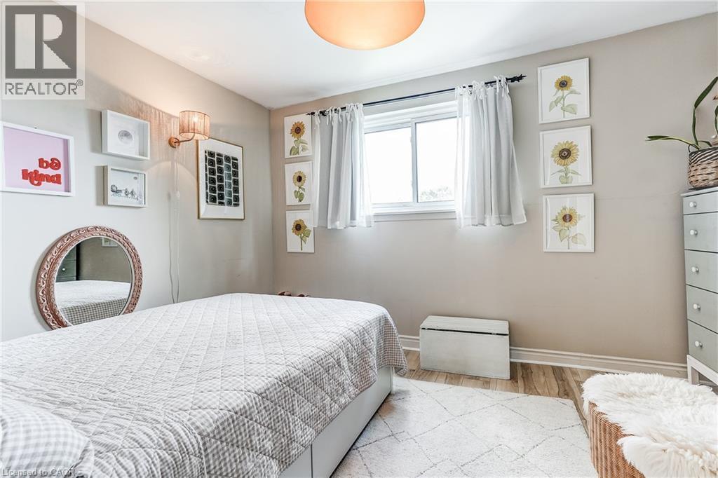 Recessed window with white trim, wood-finish flooring, and a wall-mounted sconce - 2488 Brookhurst Road, Mississauga, ON - Indoor Photo Showing Bedroom