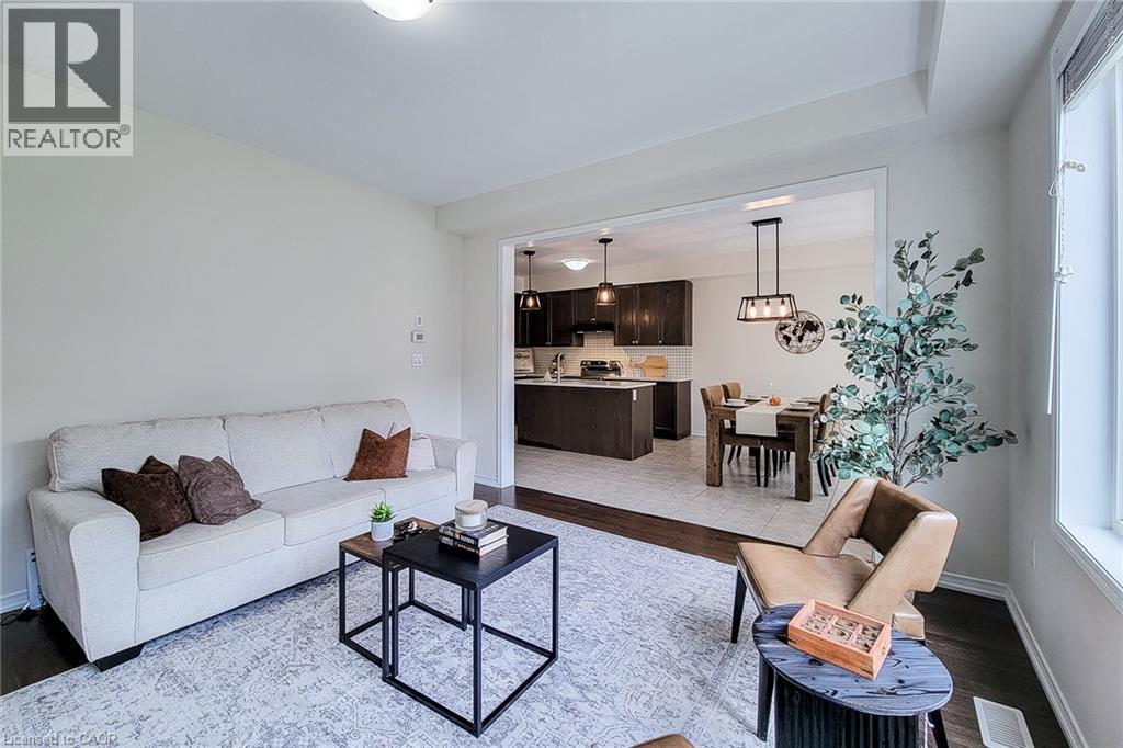 Open concept living space with recessed lighting, dark wood-finish flooring, and a broad window - 11 Esther Crescent, Thorold, ON - Indoor Photo Showing Living Room