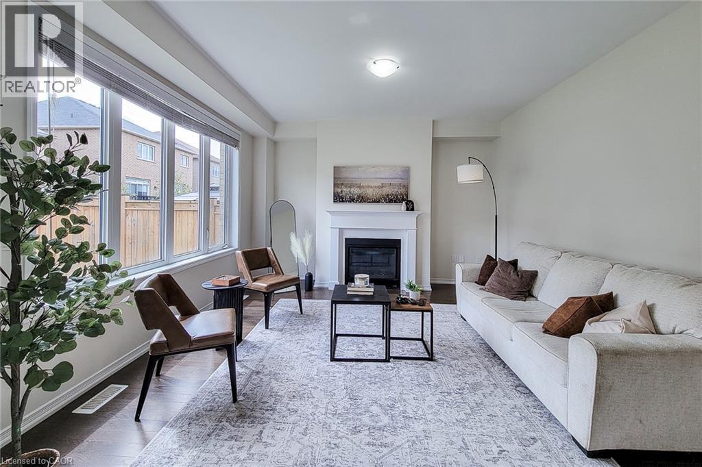 Expansive window array, wood-finish flooring, recessed lighting, and a prominent fireplace with a classic mantel - 11 Esther Crescent, Thorold, ON - Indoor Photo Showing Living Room With Fireplace