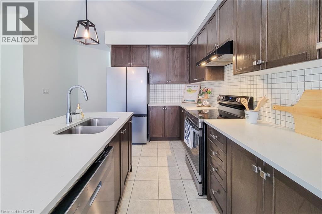 Kitchen featuring a double basin sink, dark wood-finish cabinetry, stainless steel appliances, and white square tile backsplash - 11 Esther Crescent, Thorold, ON - Indoor Photo Showing Kitchen With Stainless Steel Kitchen With Double Sink With Upgraded Kitchen