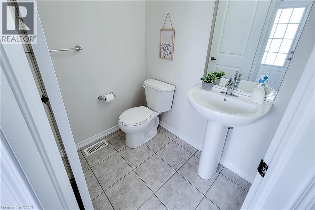 Pedestal sink with chrome faucet, toilet, and tile flooring - 11 Esther Crescent, Thorold, ON - Indoor Photo Showing Bathroom