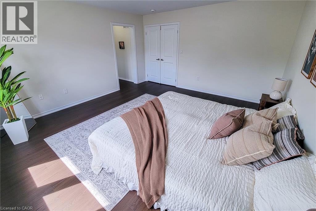 Dark wood-finish flooring with light wall tones - 11 Esther Crescent, Thorold, ON - Indoor Photo Showing Bedroom