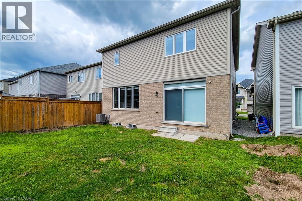 Rear exterior featuring a sliding glass door, brick and siding facade, and a wood fence - 11 Esther Crescent, Thorold, ON - Outdoor With Exterior