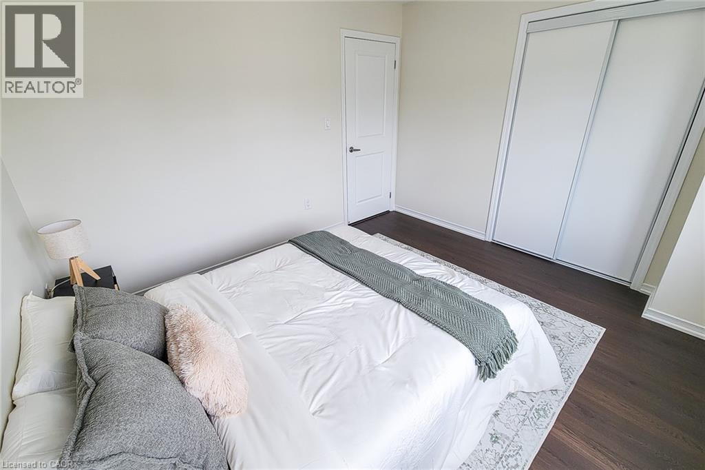 Dark wood-finish flooring with white baseboards - 11 Esther Crescent, Thorold, ON - Indoor Photo Showing Bedroom