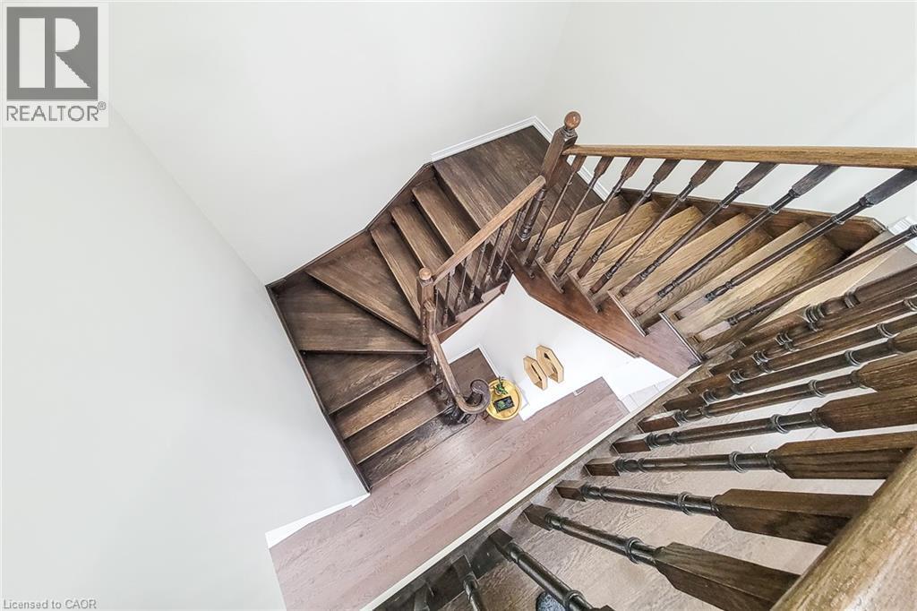 Hardwood staircase with turned balusters, wood handrail, and white walls - 11 Esther Crescent, Thorold, ON - Indoor Photo Showing Other Room