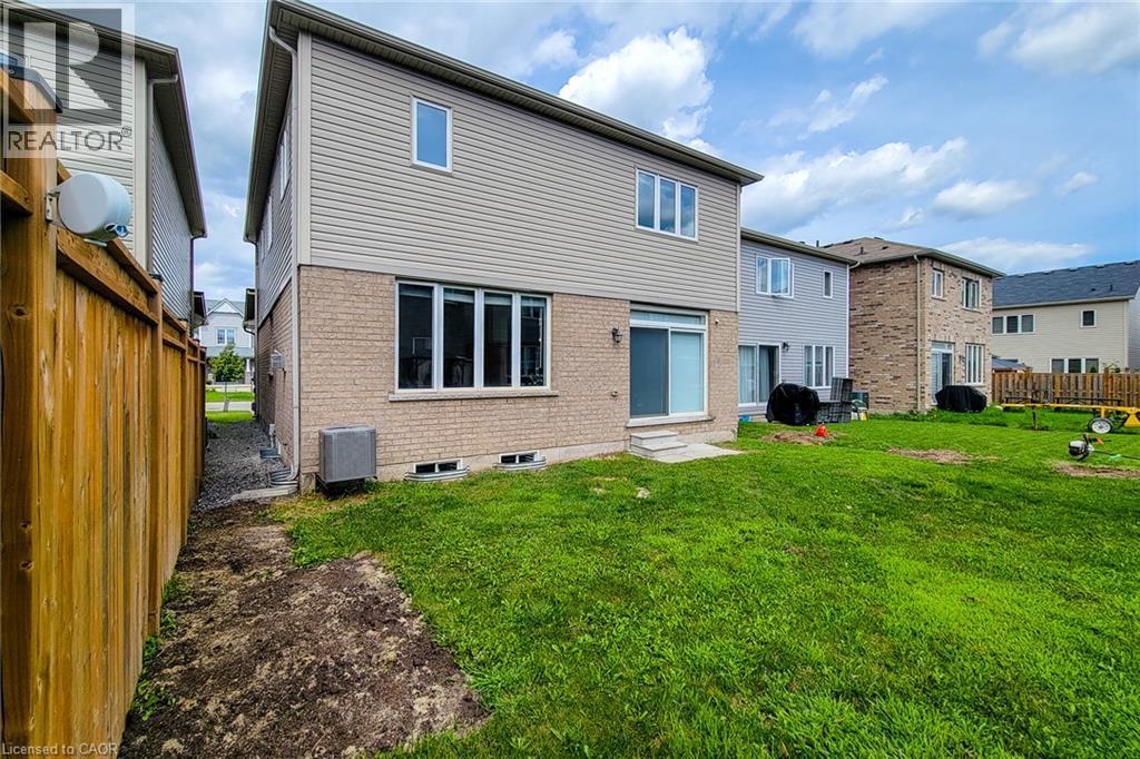 Expansive rear yard with a sliding glass door, a wooden fence, and a brick and siding exterior - 11 Esther Crescent, Thorold, ON - Outdoor With Exterior