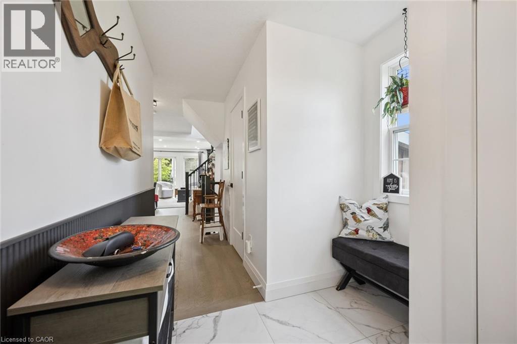 Entryway featuring white marble-look tile, wood-finish flooring, a built-in window bench, and wainscoting - 439 Beaver Creek Road, Waterloo, ON - Indoor Photo Showing Other Room
