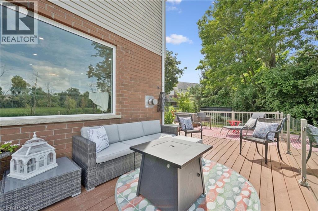 Expansive wood deck with white railings, brick exterior, and a large rectangular window - 439 Beaver Creek Road, Waterloo, ON - Outdoor With Deck Patio Veranda With Exterior