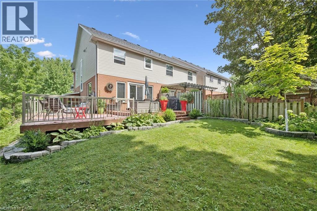 Expansive green lawn with a wooden privacy fence - 439 Beaver Creek Road, Waterloo, ON - Outdoor With Deck Patio Veranda