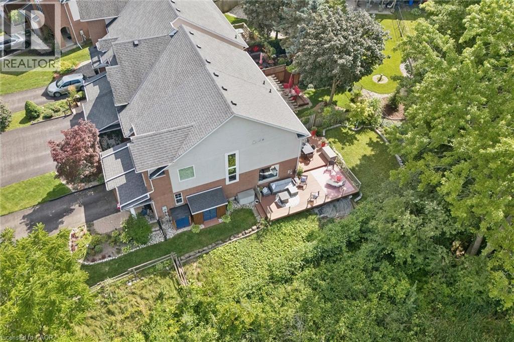 Expansive rear deck, multi-level property architecture, pitched shingle roof, paved driveway, and established landscaping - 439 Beaver Creek Road, Waterloo, ON - Outdoor With View