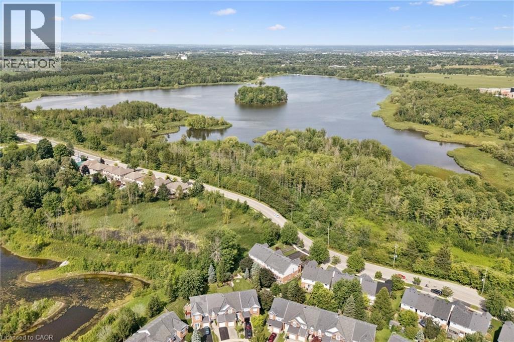 Aerial perspective showcasing residential properties, a natural body of water, and extensive surrounding green spaces - 439 Beaver Creek Road, Waterloo, ON - Outdoor With View