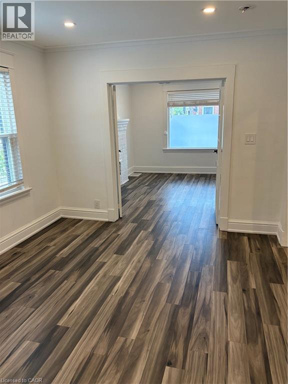Unfurnished room with dark wood-style flooring, crown molding, healthy amount of natural light, and recessed lighting - 1090 Cannon Street E Unit# 2, Hamilton, ON - Indoor Photo Showing Other Room