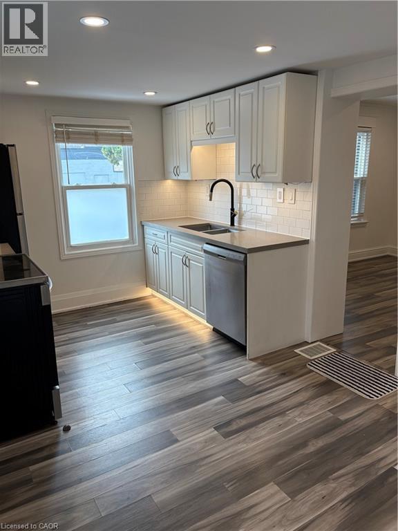 Kitchen with range, dark wood-style flooring, dishwashing machine, recessed lighting, and white cabinetry - 1090 Cannon Street E Unit# 2, Hamilton, ON - Indoor Photo Showing Kitchen