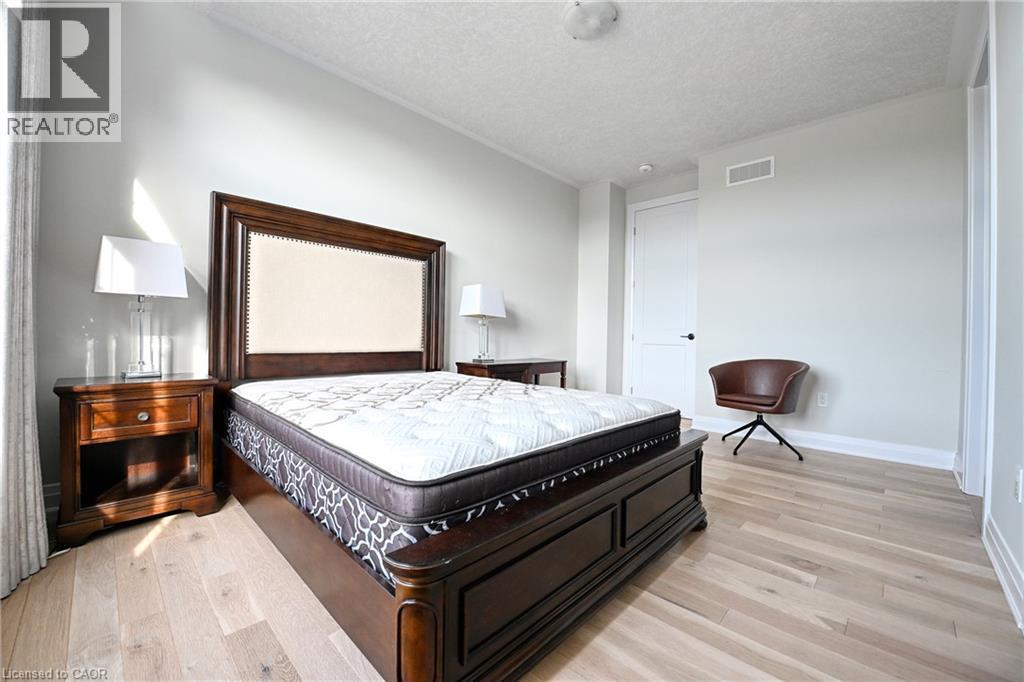 Light wood-finish flooring with crisp white walls - 923 Eaglecrest Court, Kitchener, ON - Indoor Photo Showing Bedroom