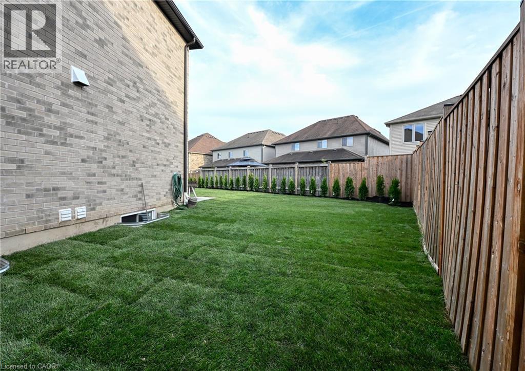 Expansive backyard featuring freshly laid sod and a privacy fence - 923 Eaglecrest Court, Kitchener, ON - Outdoor