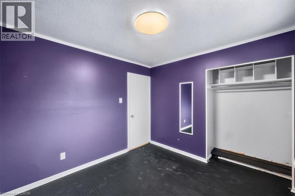 Wall-to-wall flooring, built-in closet with shelving and hanging rod, recessed wall mirror, overhead flush-mount lighting, and white trim - 27 Gretna Court, Hamilton, ON - Indoor Photo Showing Other Room