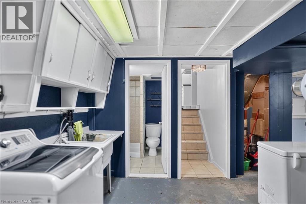 Laundry area with white cabinetry, a utility sink, and a built-in light fixture - 27 Gretna Court, Hamilton, ON - Indoor Photo Showing Laundry Room