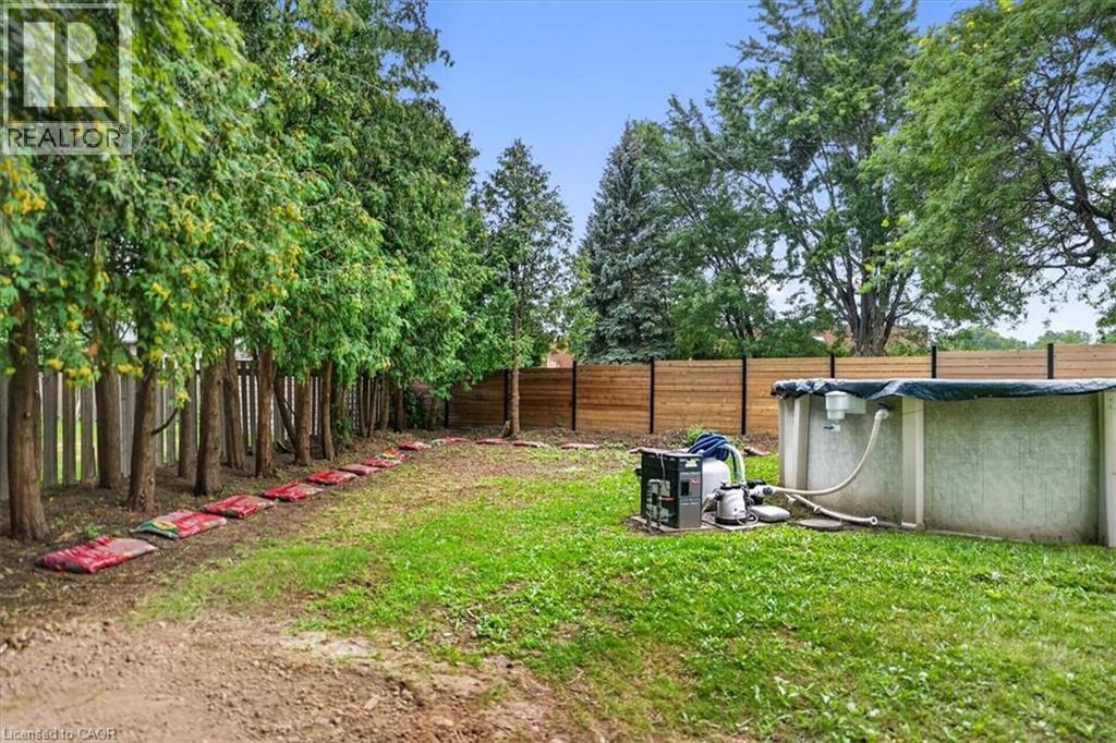 Above-ground pool with equipment, set within a grassy area - 27 Gretna Court, Hamilton, ON - Outdoor With Above Ground Pool