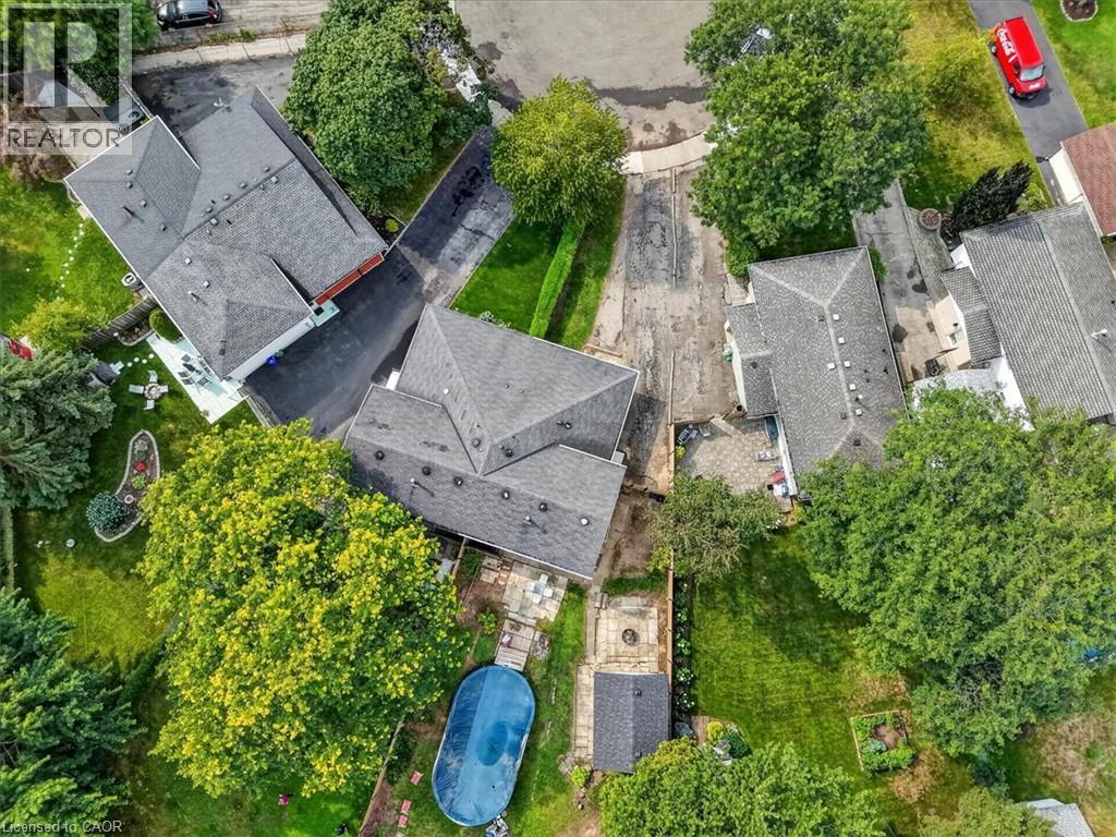 Landscaped property with mature trees, expansive green lawn, and a covered swimming pool - 27 Gretna Court, Hamilton, ON - Outdoor With View