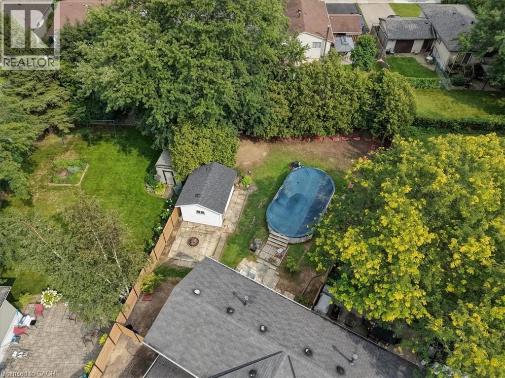 Expansive backyard featuring a covered pool, detached shed, and mature trees - 27 Gretna Court, Hamilton, ON - Outdoor