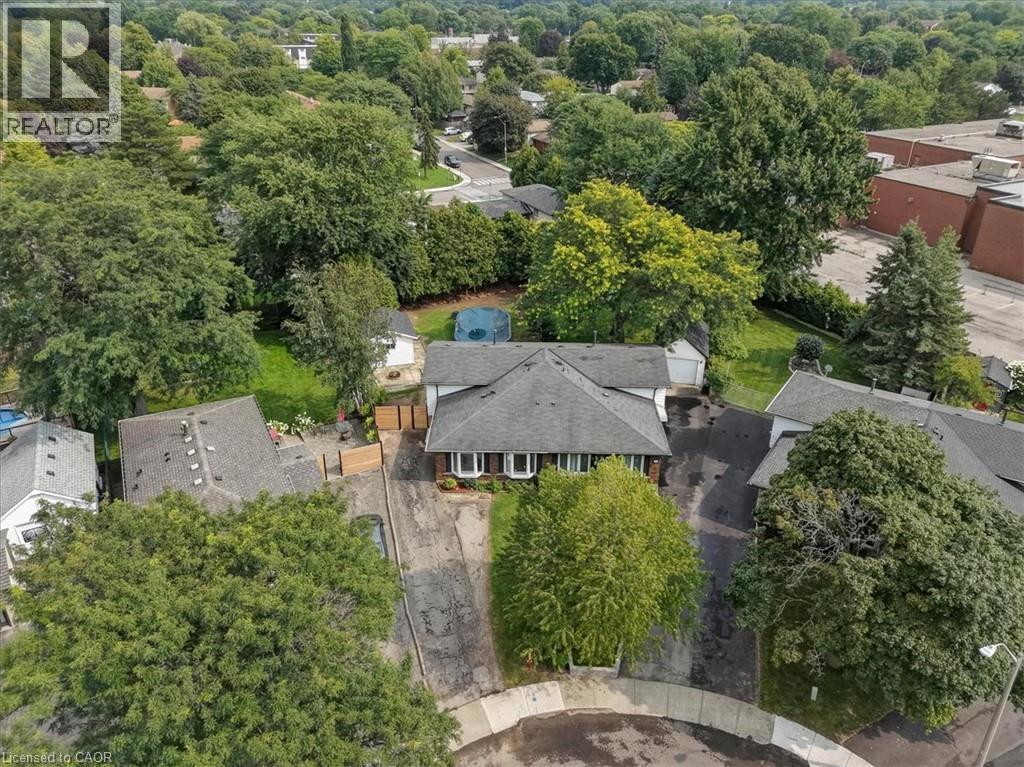 Shingle roof residence with a paved driveway, detached garage, and mature tree landscaping - 27 Gretna Court, Hamilton, ON - Outdoor