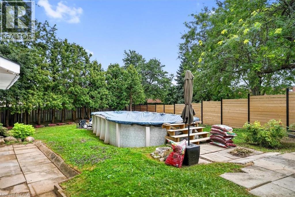 Expansive backyard featuring an above-ground pool with wood stairs, a new wood privacy fence, and mature perimeter trees - 27 Gretna Court, Hamilton, ON - Outdoor With Above Ground Pool With Backyard