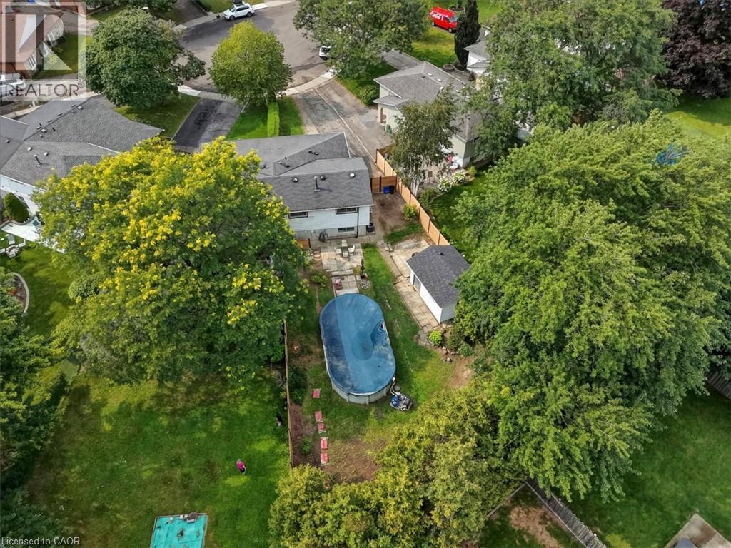 Expansive backyard with an above-ground pool, stone patio, and mature trees - 27 Gretna Court, Hamilton, ON - Outdoor With View