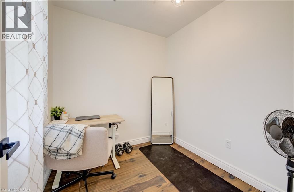 Hardwood-finish flooring, white painted walls, and a modern light fixture - 34 St Clair Avenue, Kitchener, ON - Indoor Photo Showing Other Room