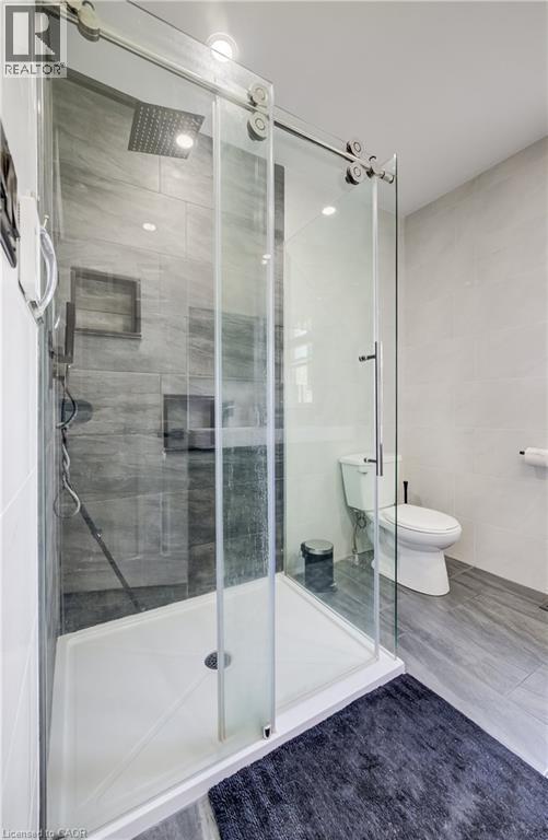 Walk-in shower with clear glass barn-door style enclosure and rainfall showerhead - 34 St Clair Avenue, Kitchener, ON - Indoor Photo Showing Bathroom