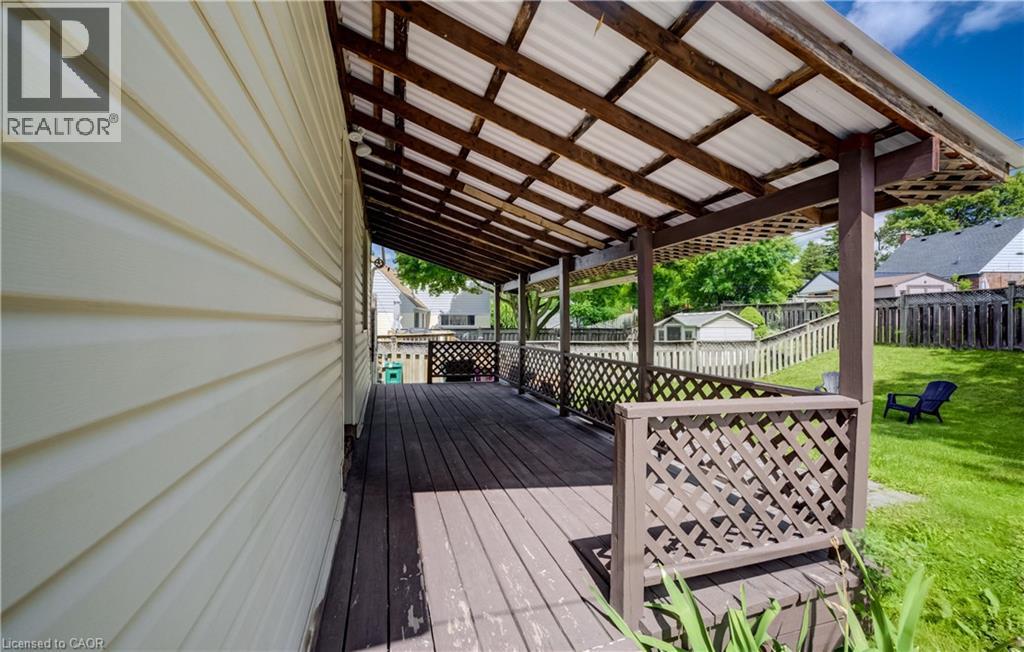 Covered outdoor deck with lattice railing and a corrugated roof - 34 St Clair Avenue, Kitchener, ON - Outdoor With Deck Patio Veranda