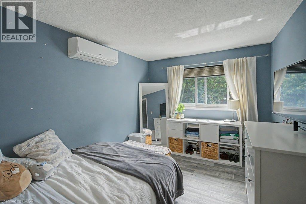 Ductless mini-split system, wood-finish flooring, and a window with natural light - 2050 Upper Middle Road Unit# 164, Burlington, ON - Indoor Photo Showing Bedroom
