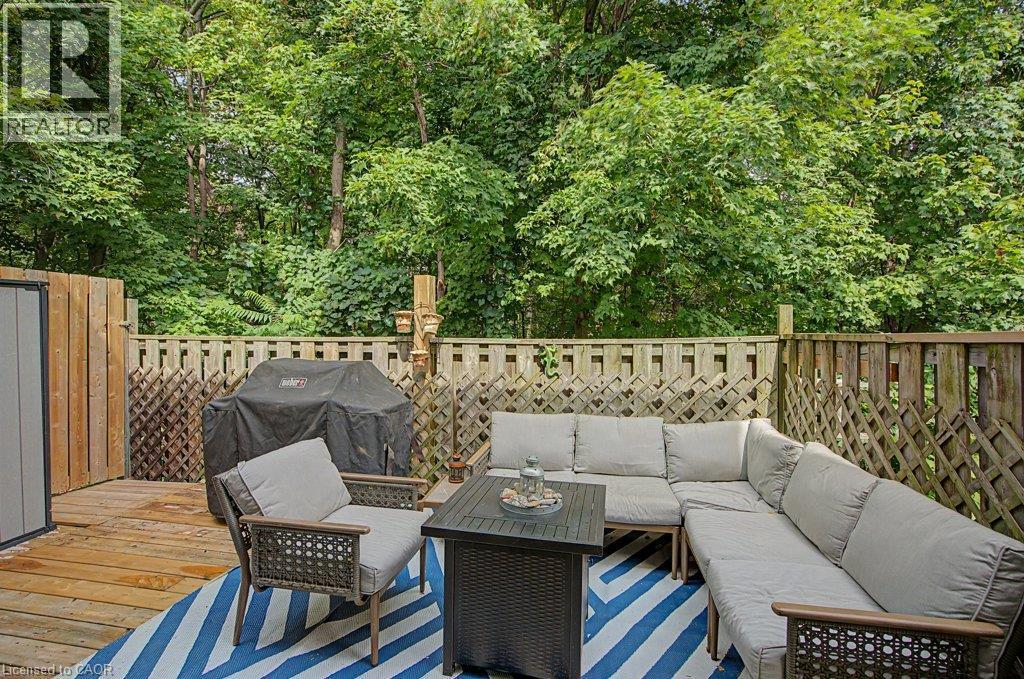 Expansive wood deck with privacy fencing and lush mature trees - 2050 Upper Middle Road Unit# 164, Burlington, ON - Outdoor With Deck Patio Veranda