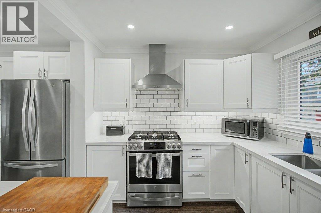 White shaker cabinetry, stainless steel appliances, subway tile backsplash, white countertops, and recessed lighting - 2050 Upper Middle Road Unit# 164, Burlington, ON - Indoor Photo Showing Kitchen With Upgraded Kitchen