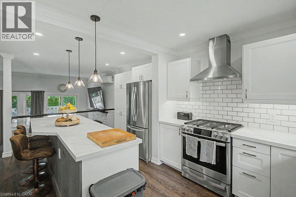 White cabinetry with brushed nickel hardware, stainless steel appliances, subway tile backsplash, white countertops, and recessed lighting - 2050 Upper Middle Road Unit# 164, Burlington, ON - Indoor Photo Showing Kitchen With Upgraded Kitchen