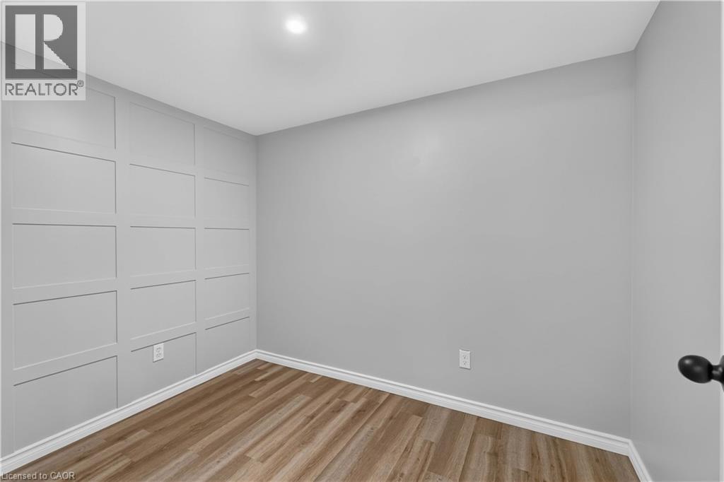 Wood-finish flooring with crisp white trim - 66 Summercrest Drive Unit# 3, Hamilton, ON - Indoor Photo Showing Other Room