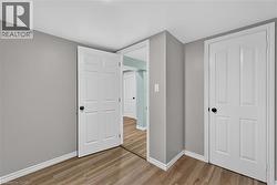 Wood-finish flooring with white trim and light gray walls -